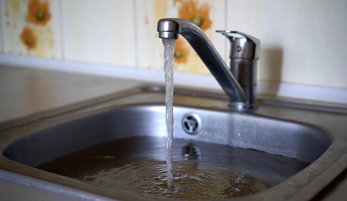 A stainless steel kitchen sink filled with water