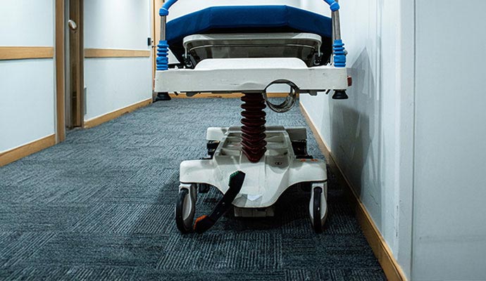 A stretcher parked on carpeted hospital corridor