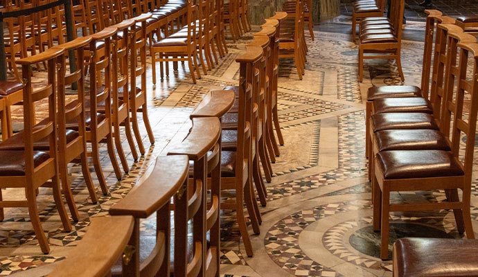 Rows of polished wooden chairs with leather seats