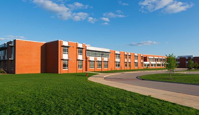 The exterior of a large, red brick school building
