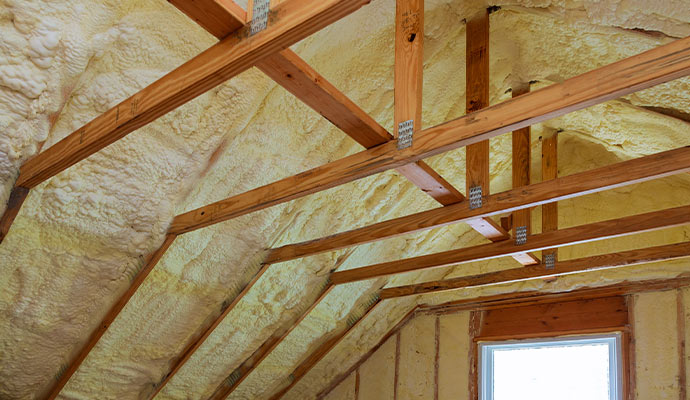 Modern spray foam insulation applied to the rafters and walls of a residential attic