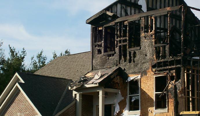 The exterior of a house showing severe structural damage from a fire
