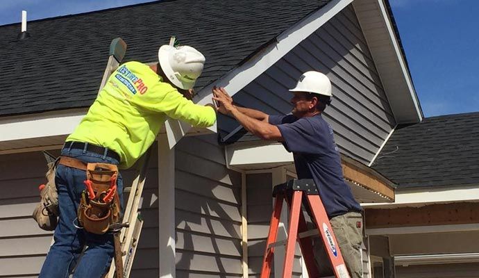 RestorePro Reconstruction team installing house siding