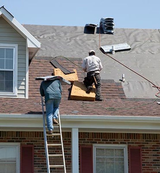 Roofing crew installing new asphalt shingles on house