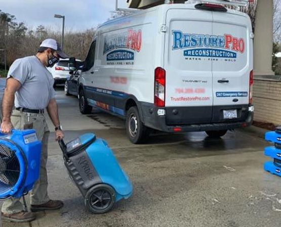 RestorePro Reconstruction professional with water damage restoration equipments
