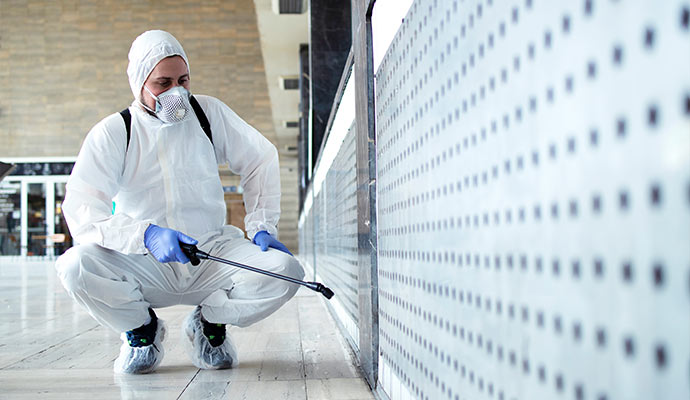 Disinfection technician spraying commercial building