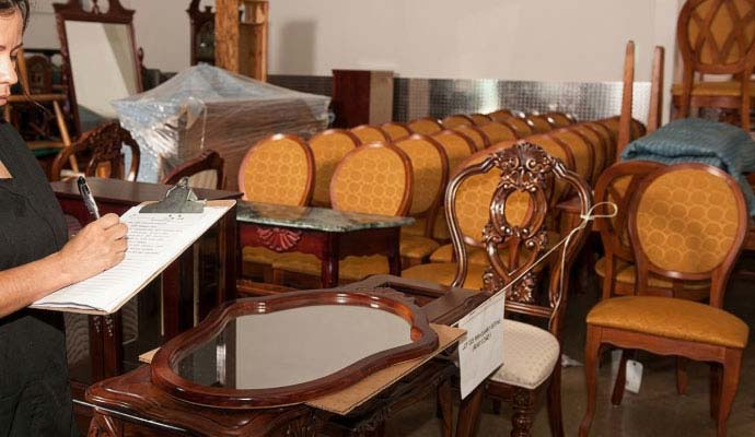 Technician inventorying restored furniture and belongings during contents restoration