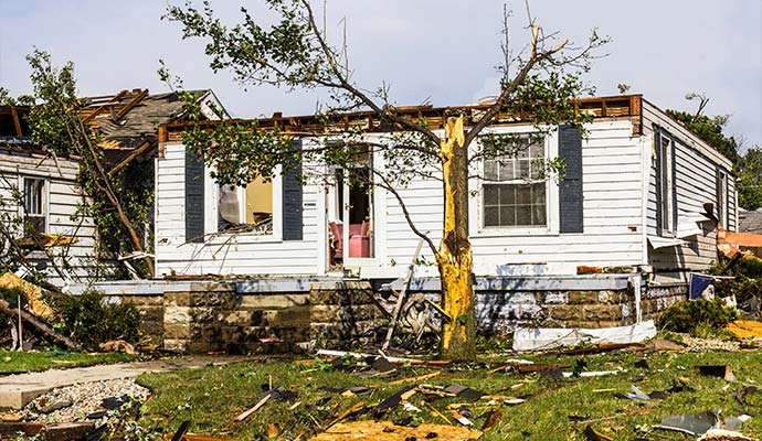 A house with significant wind and structural damage after a tropical storm