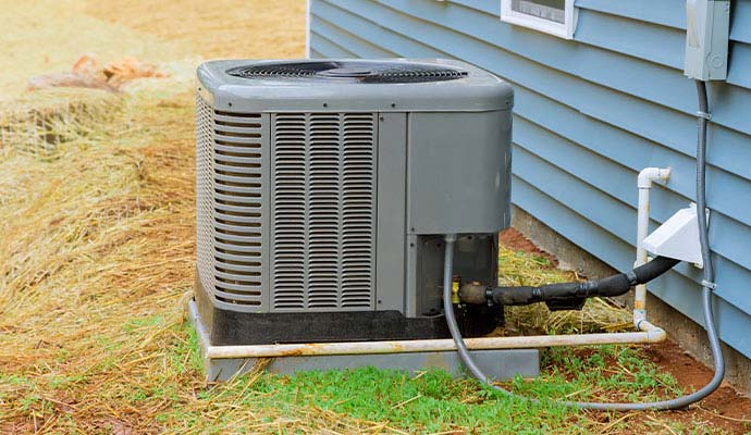 Outdoor HVAC unit and discharge line installed beside a residential house