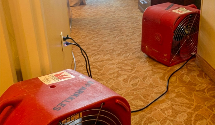 Red air movers drying carpet