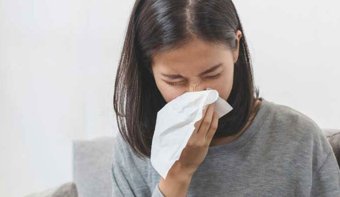 Woman sneezing due to bad indoor air quality